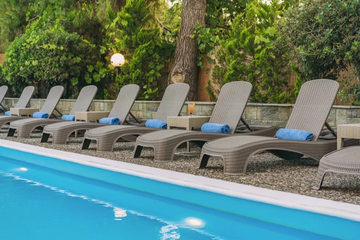 A poolside area with lounge chairs and a swimming pool.