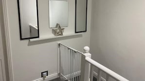 A staircase with a white railing and a metal handrail, leading to an upper floor. - New Day Properties-Seaside House-next to beach (South Shields)