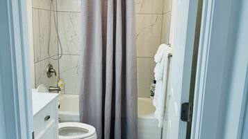 Ein Badezimmer mit Toilette, Badewanne und Dusche.