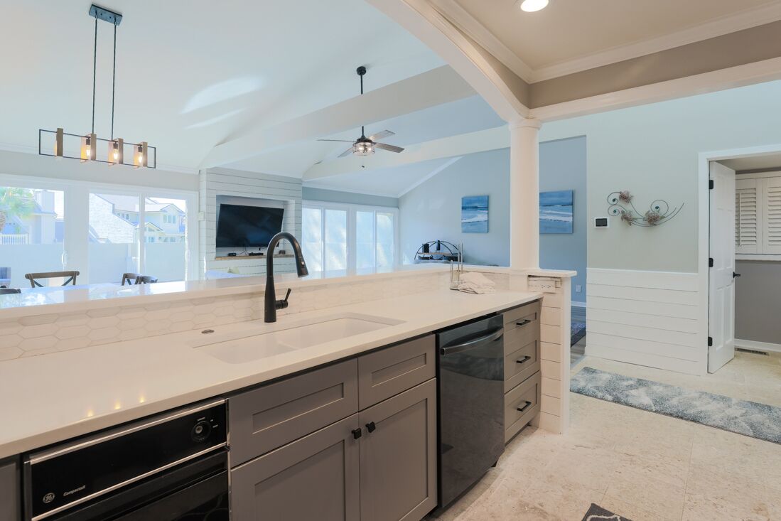 A spacious kitchen with a large island, modern appliances, and a view to the outside.