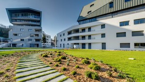 Un edificio moderno con un diseño angular único, que cuenta con varios balcones y grandes ventanales.