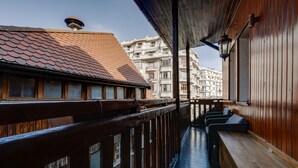 Un balcón de madera con vistas a edificios cercanos.