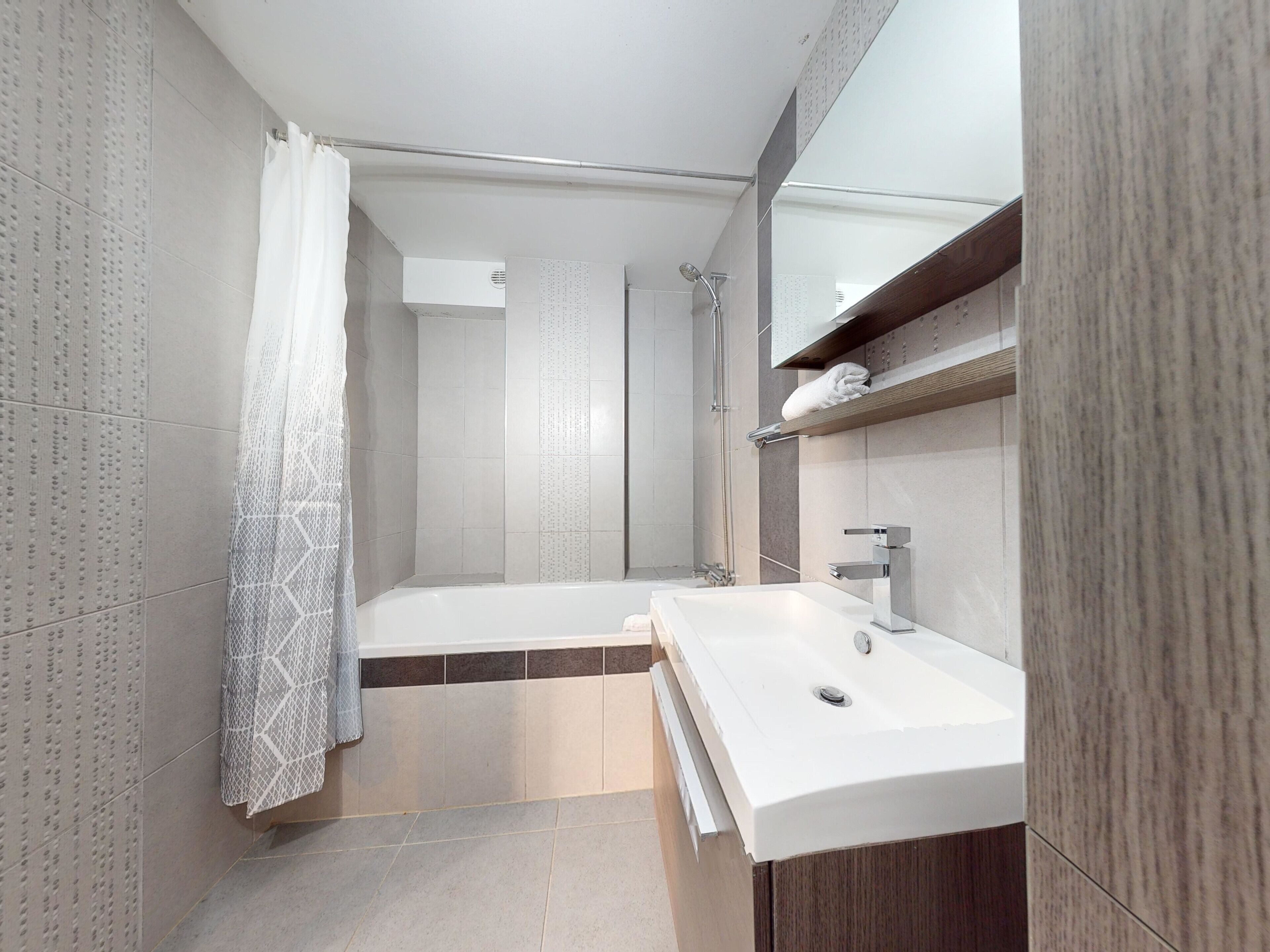 A modern bathroom with a bathtub, a sink, and a shower.