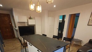 Une cuisine moderne avec un îlot central, des armoires blanches et un tapis à motifs.