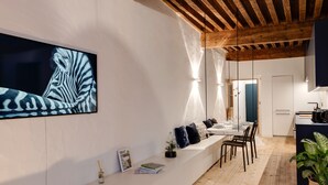 A modern kitchen with wooden beams, a dining area with a bench, and a large zebra artwork on the wall. - L'Appart' - Ideal for a stay in the city center, near the Lake (Annecy)