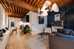 Un salon moderne avec un plafond en bois, un coin repas et un espace salon confortable agrémenté d’une cheminée.