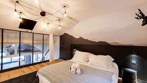 Une chambre à coucher moderne avec un lit, une grande fenêtre et une fresque représentant une montagne sur le mur.