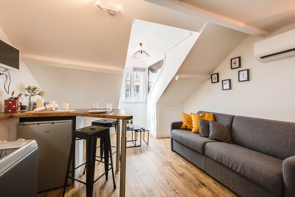 Un appartement moderne comprenant une cuisine, un coin repas et un salon.