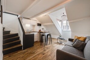 Un appartement de style « loft » comprenant une cuisine, un coin repas et un espace de vie.