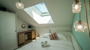 A bedroom with a skylight, a bed with pillows, a bedside table, a desk, and a wardrobe. - The Azalea, beautiful quiet apartment for 4 people! (Doussard)