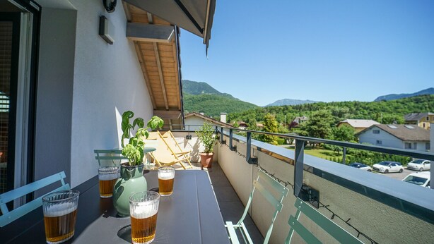 A balcony with a table, potted plants, and glasses of beer. - The Azalea, beautiful quiet apartment for 4 people! (Doussard)