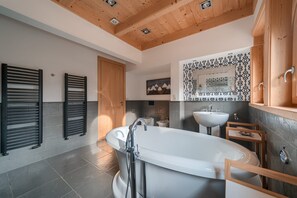 A modern bathroom with a freestanding bathtub, a sink, and a wooden ceiling. - Rich Witch Villa&SPA (Koscielisko)