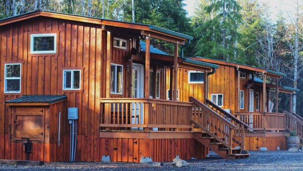 Una baita di legno con un portico e una scala che conduce all'ingresso.