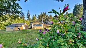 A house with a large lawn and a garage. - 4 guest · Eddie Bauer`s former Beachfront Cottage (Sekiu)