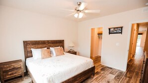 A bedroom with a wooden bed, a ceiling fan, and a nightstand. - Your perfect Base Camp: Central, pet friendly w/ Starlink (Forks)