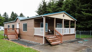 A single-story cabin with a covered porch and a small staircase leading to the entrance. - Your perfect Base Camp: Central, pet friendly w/ Starlink (Forks)