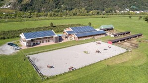A large equestrian facility with solar panels, stables, and a riding arena. - Studio 'Agriturismo L'isola Del Cavallo 2' with Mountain View, Shared Garden and Wi-Fi (Talamona)