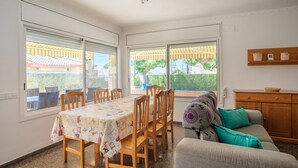 Een eetgedeelte met een tafel, stoelen, een bank en een houten kast.