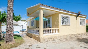 Une maison de plain-pied avec un balcon, une piscine et des fondations en pierre.