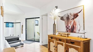 Een modern interieur met een trap, een houten kast en een prent van een dier.
