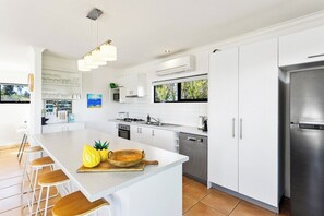 Enjoy cooking in this well-lit kitchen with a central island and bar stools.