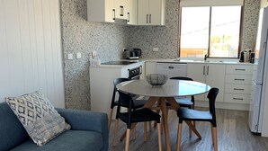 Ein kompakter Wohnbereich mit Küchenzeile, Essplatz und Sofa.