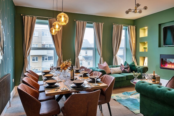Un comedor con una mesa de madera dispuesta para seis personas, rodeado de sillas marrones.