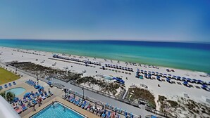 A resort with a swimming pool, beach area with umbrellas, and a clear view of the ocean. - Regency Towers #812 | Comp. Beach Service, Beautiful Views + Amenities (Panama City Beach)