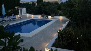 A rectangular swimming pool with a tiled deck, surrounded by lounge chairs and a small table. - Chic bungalow in a quiet and central location with private pool - close to the beach (Calpe)