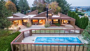 Une maison moderne dotée d’une grande terrasse, d’une piscine et d’un jardin bien entretenu.
