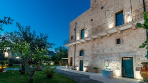 A stone building with a balcony, a door, and a small window. - Masseria Antoglia (Villa Castelli)