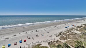 A beach with umbrellas and people.