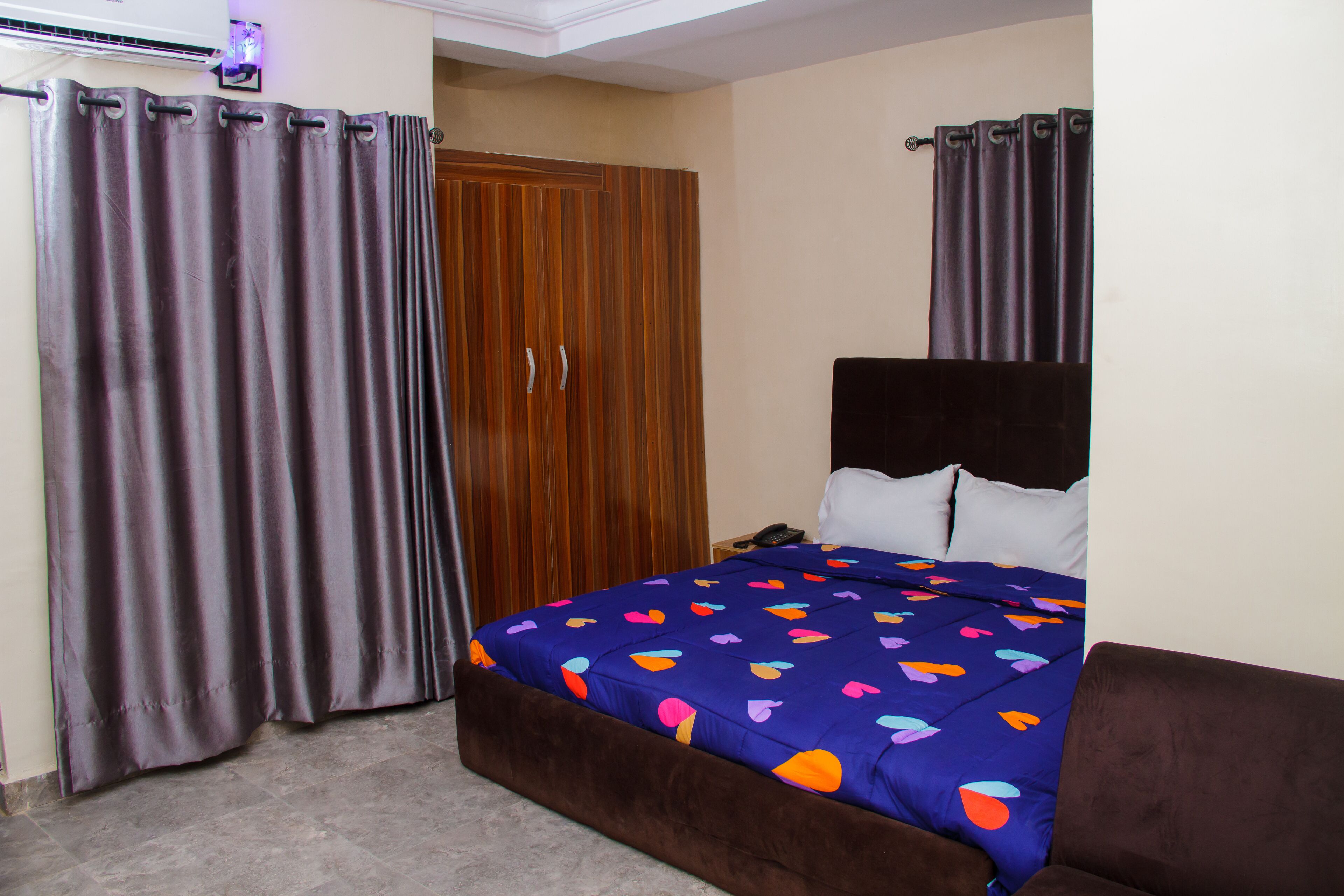 A bedroom with a bed, a wardrobe, and curtains.