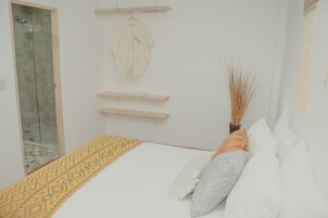 Un dormitorio con cama, armario y zona de ducha.