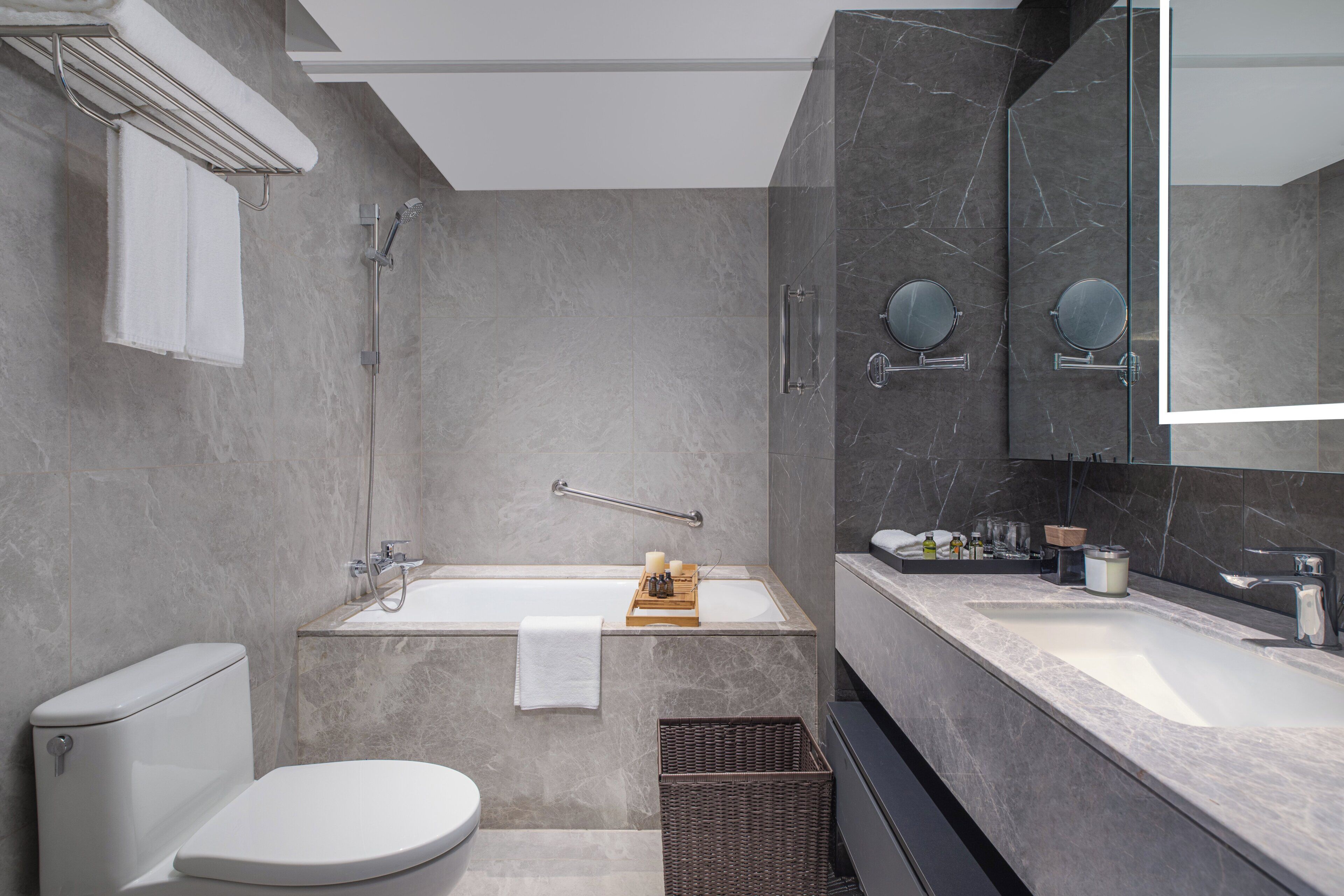 Une salle de bain moderne équipée de toilettes, d’une baignoire et d’un lavabo.