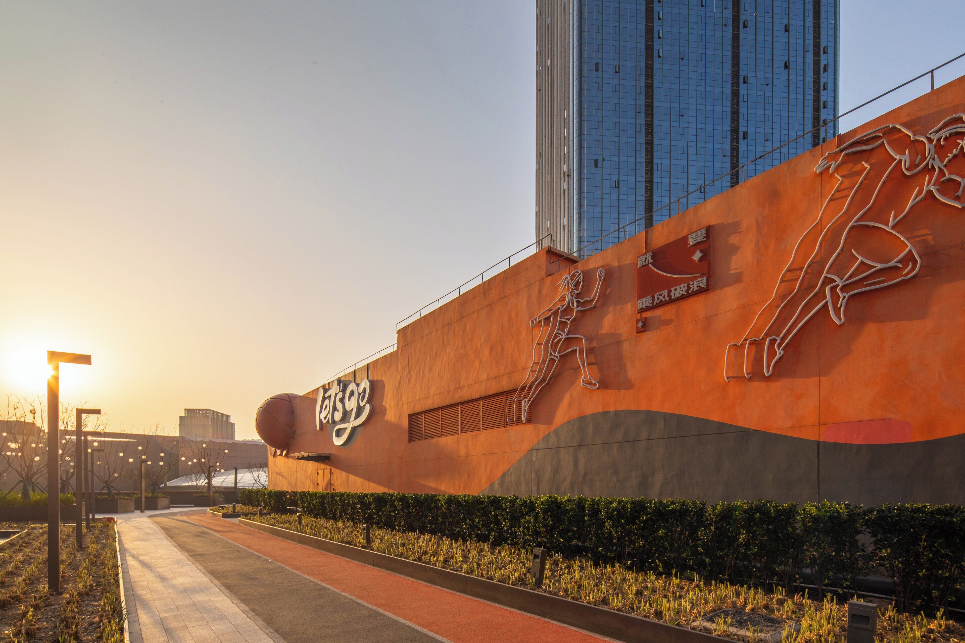 A modern building with a large sign reading "Let’s Go" and a mural of a running figure.