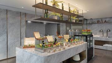 Enjoy a meal at the buffet with multiple serving stations and a selection of beverages on display.