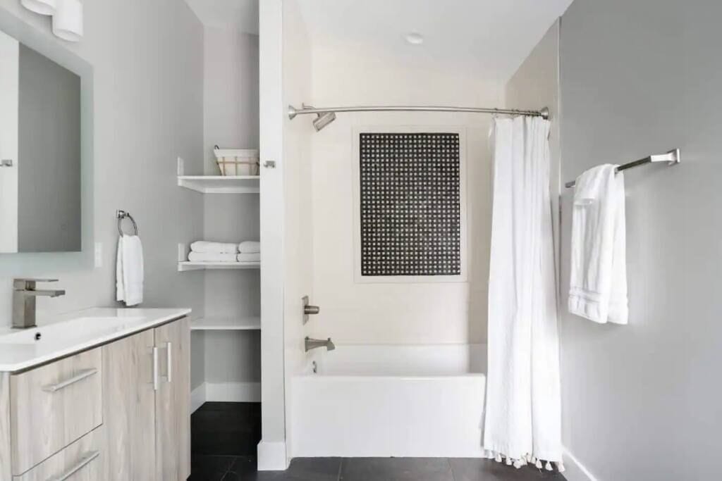 Bathtub, hair dryer, towels, shampoo
