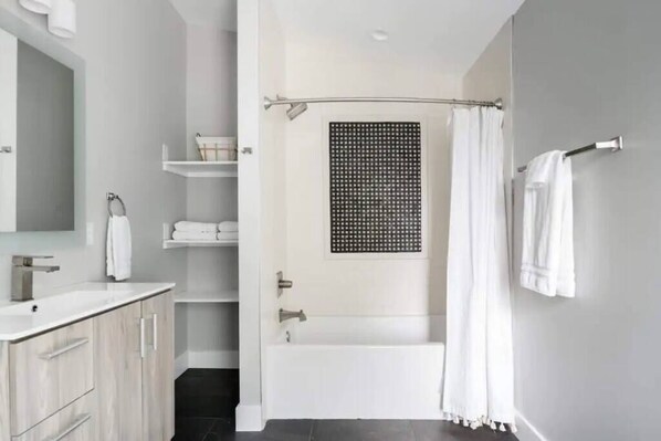 Bathtub, hair dryer, towels, shampoo