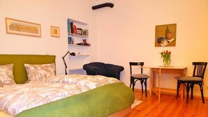 A bedroom with a bed, a desk, two chairs, and a bookshelf. - Cozy vacation apartment near the Müggelsee lake (Berlin)