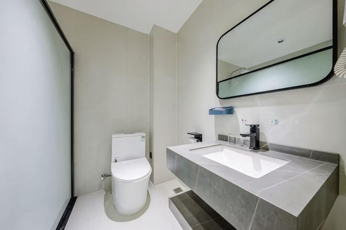 Une salle de bain moderne avec des toilettes, un lavabo et un miroir.