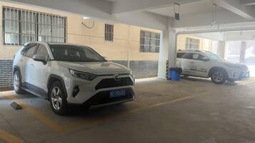 A parking garage with two white SUVs parked inside.