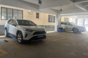 Un parking où sont garés deux SUV blancs.