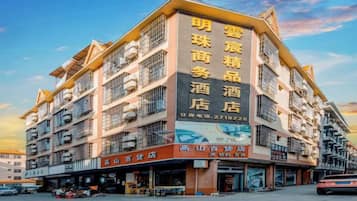A multi-story hotel with a prominent sign advertising various services.