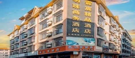 A multi-story hotel with a prominent sign advertising various services.