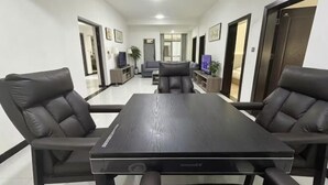 Une salle de conférence avec une longue table et quatre chaises, un téléviseur et une plante.