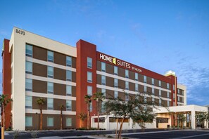 Een meerlaags hotel met een modern ontwerp, met een opvallend "Home2Suites" bord.
