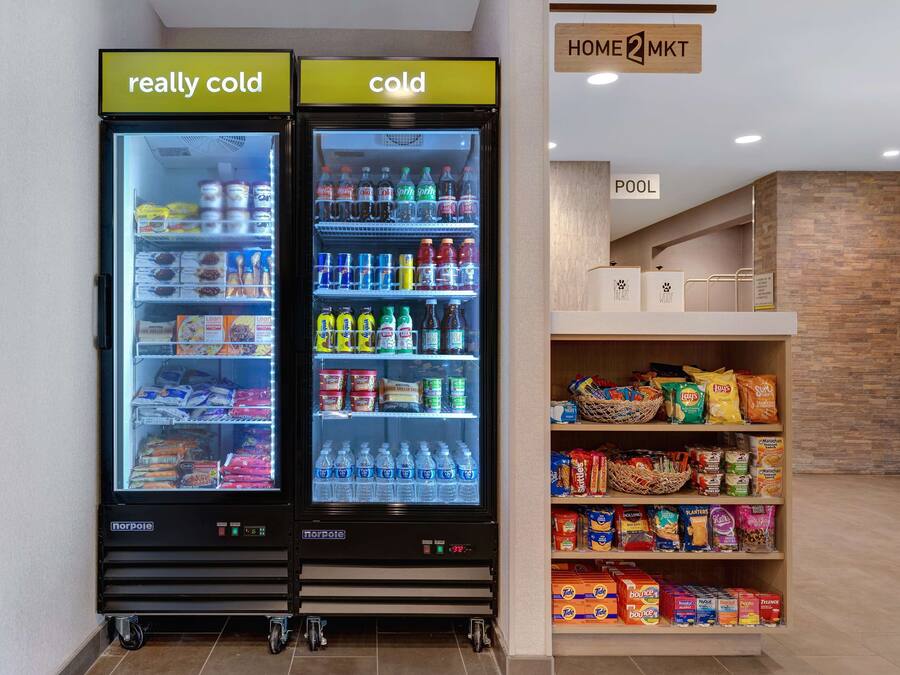 Deux distributeurs de boissons réfrigérés, étiquetés « très froid » et « froid », proposent une variété de boissons et d’en-cas.