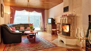 A cozy living room with a leather sofa, a fireplace, and a television. - **** Holiday home 'old farmhouse' (Burgen)