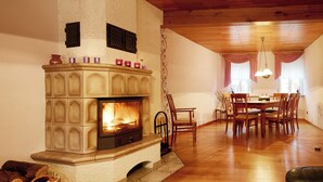 A cozy living room with a fireplace, wooden dining table, and chairs. - **** Holiday home 'old farmhouse' (Burgen)